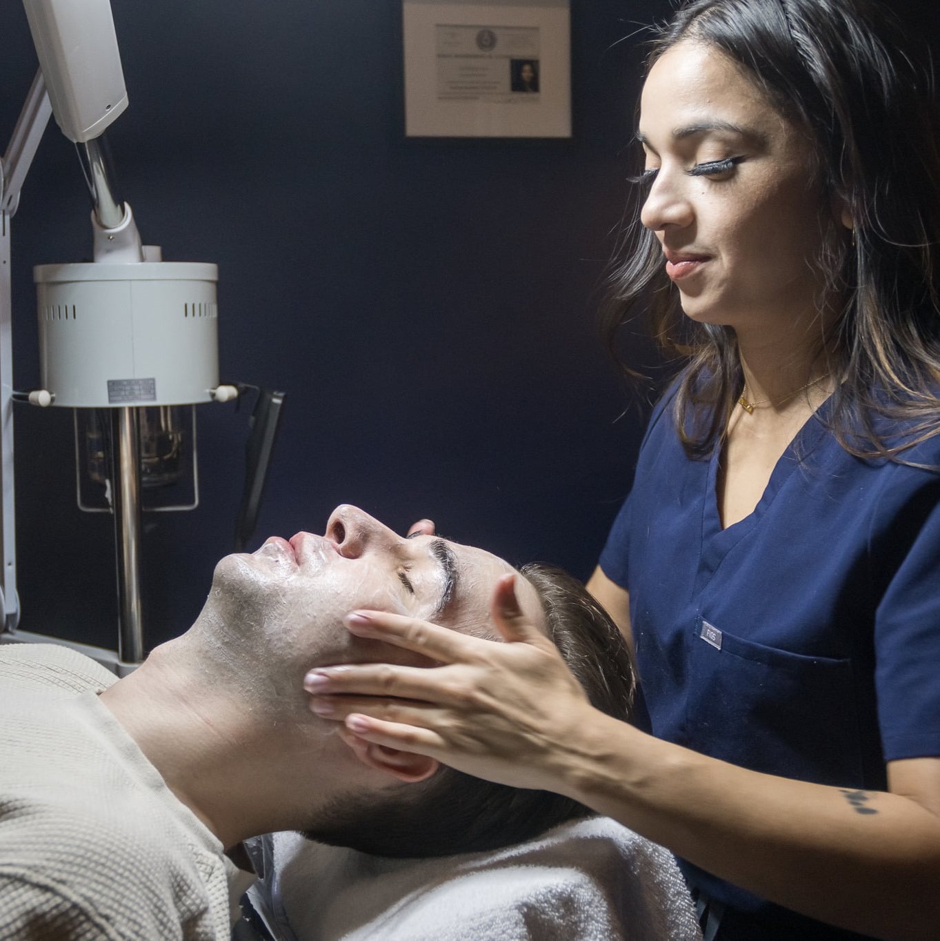 Esthetician applying a chemical peel to a male client’s face at Flycatcher in Austin